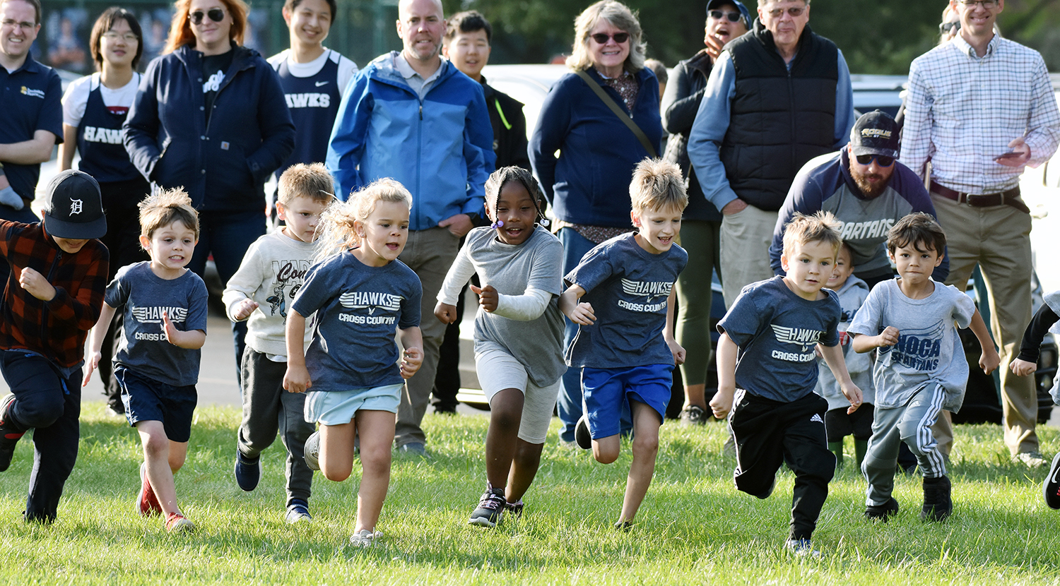 young student athletes running on grass