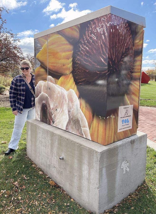 Art teacher Kristin Kowalski with her artwork in downtown Toledo