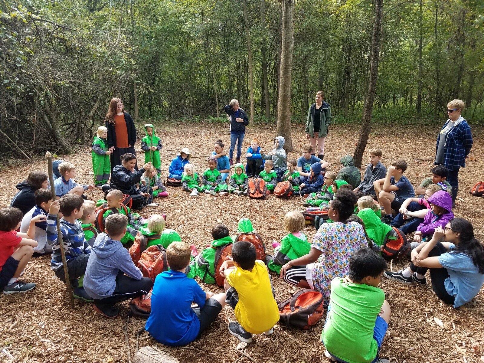 students sitting in circle in woods